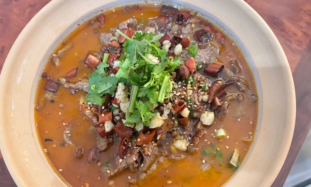 Spicy numbing broth with tender beef slices at HuaYuChuan, a Chinese Restaurant in Flushing